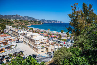 High angle view of townscape by sea against clear sky