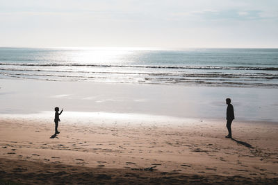 People on beach against sky