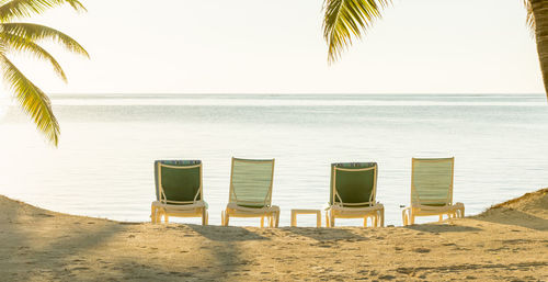 Chairs on beach against sky