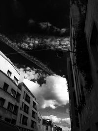 Low angle view of buildings against cloudy sky