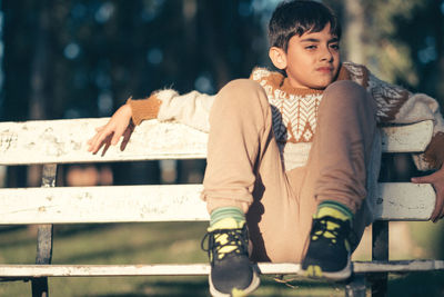 Portrait of pre adolescent child sitting on a bench