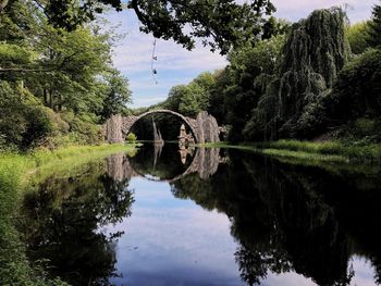 Arch bridge over lake against sky