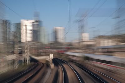 Blurred motion of train in city against sky