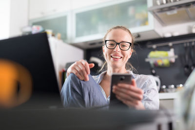 Business woman using smart phone while sitting at home