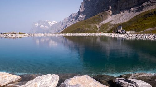 Scenic view of lake by snowcapped mountains against sky