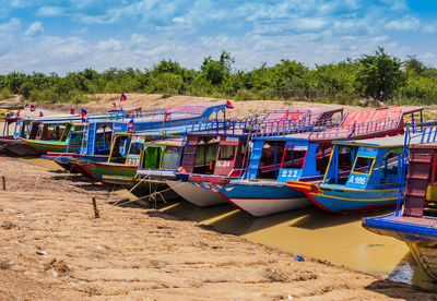 View of boats moored on beach against sky