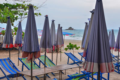 Panoramic shot of deck chairs on beach against sky