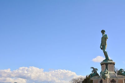 Low angle view of statue against blue sky