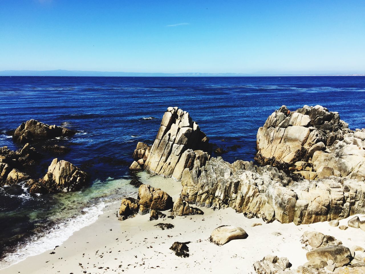 sea, clear sky, blue, horizon over water, water, tranquil scene, scenics, tranquility, beauty in nature, nature, rock - object, shore, rock formation, idyllic, rock, day, coastline, remote, outdoors, non-urban scene, no people, non urban scene, sky, calm, seascape, ocean, sunny, majestic