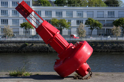 Red umbrella by river in city