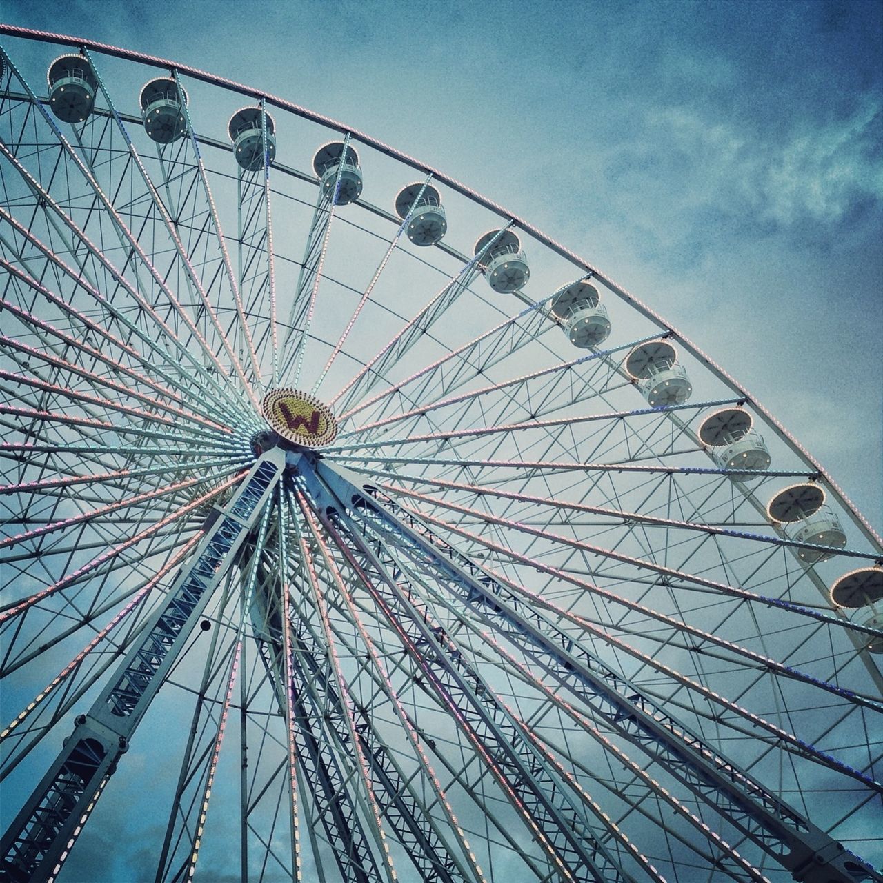 amusement park, ferris wheel, amusement park ride, arts culture and entertainment, low angle view, sky, blue, big wheel, built structure, large, fun, fairground, enjoyment, metal, fairground ride, outdoors, day, leisure activity, rollercoaster, architecture