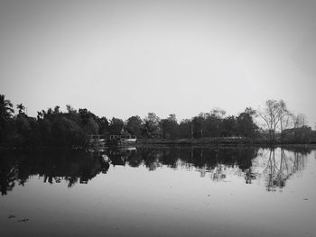 Reflection of trees in lake against clear sky