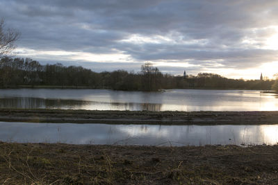 Scenic view of lake against sky at sunset