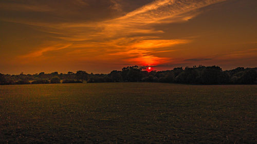 Scenic view of field against romantic sky at sunset