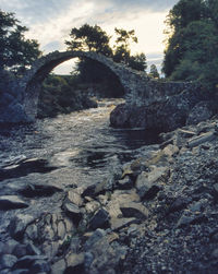 Arch bridge over river against sky