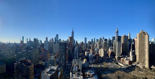 Panoramic view of city buildings against clear sky