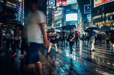 People walking on wet street at night