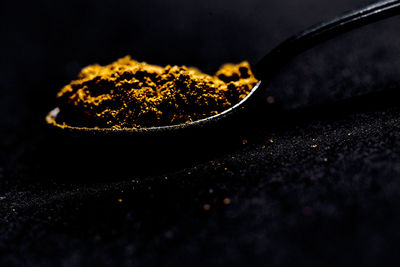 Close-up of turmeric powder in spoon at table