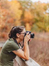 Young woman photographing with dslr camera