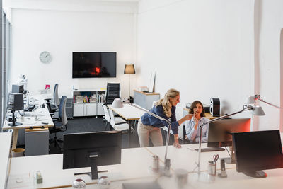 Female entrepreneurs discussing over computer in office