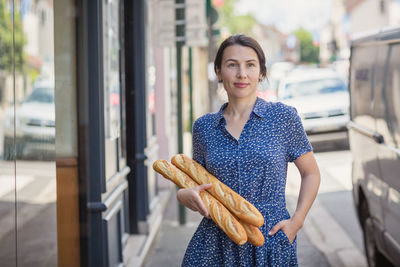 Young woman buying a french baguette