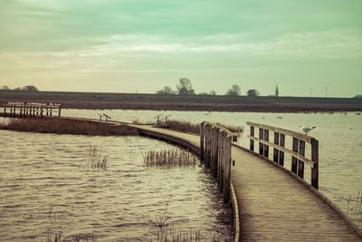 Pier over river against sky