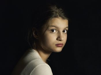 Close-up of boy against black background