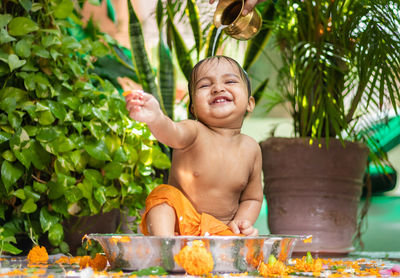 Cute toddler baby boy bathing in decorated bathtub at outdoor from unique perspective