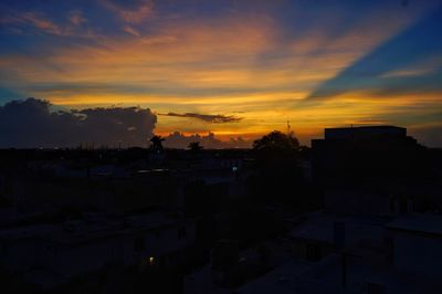 Silhouette buildings against sky during sunset