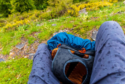 A first-person pov shot of a hiker sitting with a backpack while it's raining in the french alps