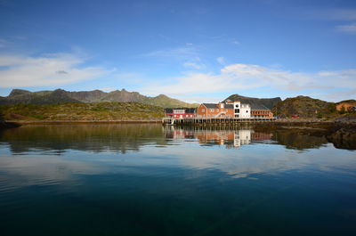 Scenic view of lake by buildings against sky