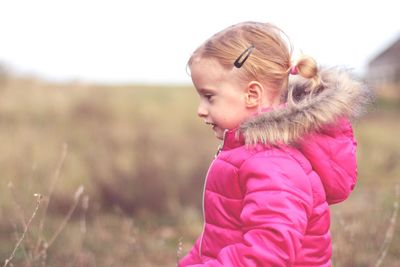 Cute girl with pink petals on field