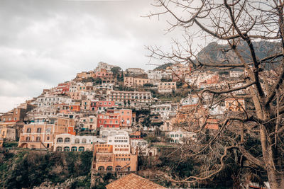 Buildings in town against cloudy sky