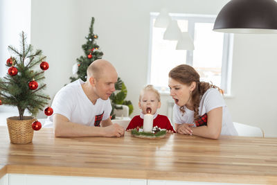 Side view of family sitting on table