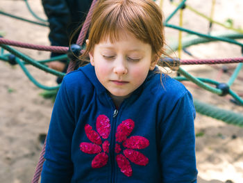 Close-up of girl sitting at playground