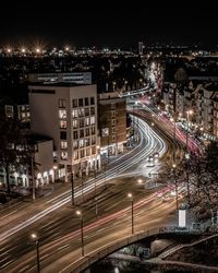 Aerial view of illuminated street amidst buildings in city