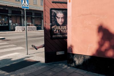 Text on wall by footpath in city