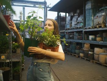 Woman holding potted plant at store