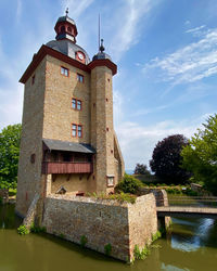 Building by river against sky