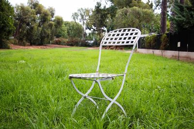 Empty chair on grassy field in park