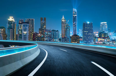 Illuminated buildings in city against sky at night