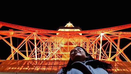 Low angle view of woman against illuminated building