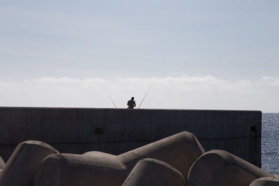 Man on sea shore against sky