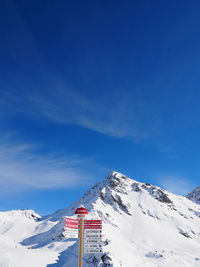 Signboard at ski resort against cloudy sky