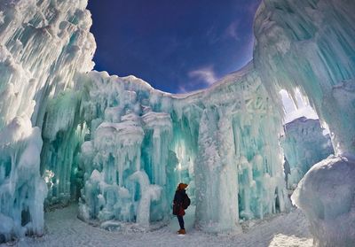 Young woman standing by ice formation