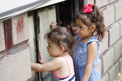 Two children playing by built structure