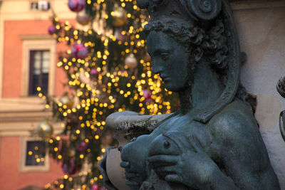 Close-up of statue against illuminated building