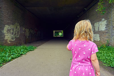 Rear view of woman standing against wall