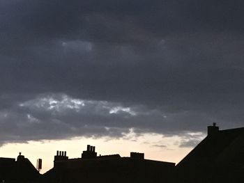 Low angle view of silhouette buildings against sky