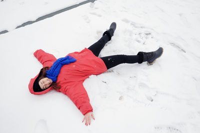 High angle view of woman making snow angel on land